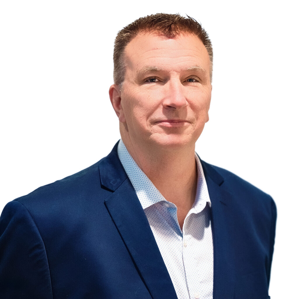 Man wearing a Navy blue blazer, a white shirt, no tie, looking at camera
